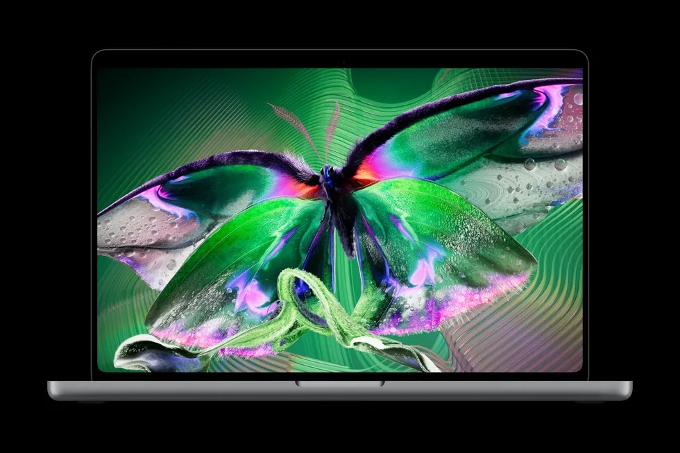 The new MacBook Pro with PROLED XDR display, open, showing a colourful moth on screen.